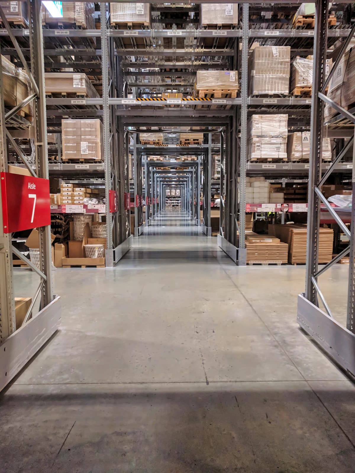 Warehouse storage aisles with racked shelves full of boxed stock